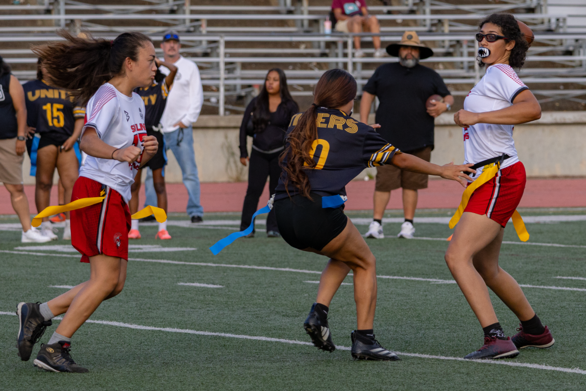 Quarterback Jane Alexander throws to a receiver as Audrey Hoffman tries to block a Unity High player