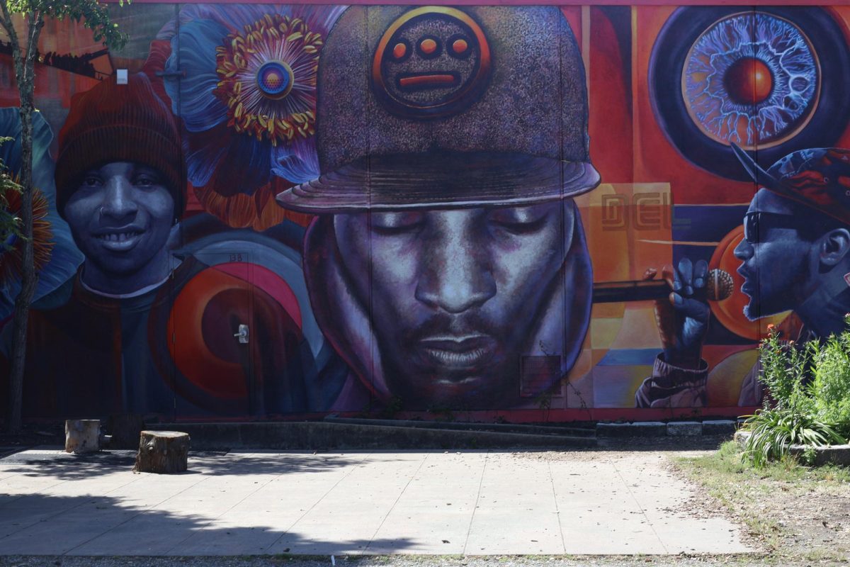 FUNKY WALL Many students have not yet seen this mural of Del the Funky Homosapien, a former Titan, that is tucked behind
the cafeteria and teachers lounge near the school garden. It covers the door of resource teacher Samuel Hopkins, who helped
secure the project through Hungry Ghost Productions. Hopkins hopes the mural will inspire students.